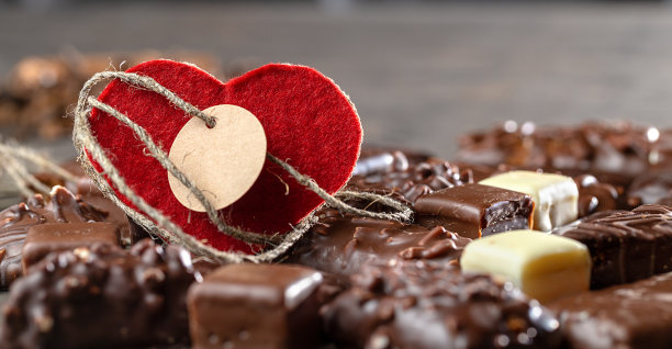 开胃食品背景。各式各样的巧克力、手工糖果和情人节的红心卡片。巧克力的背景。图片下载