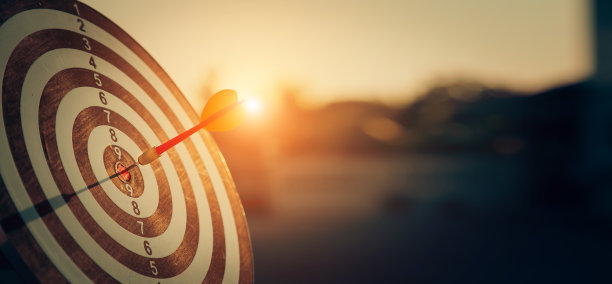 靶心靶或飞镖靶板上有红色的飞镖箭，射中靶心，用于商业瞄准和赢得目标的商业理念。图片下载