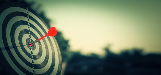 靶心靶或飞镖靶板上有红色的飞镖箭，射中靶心，用于商业瞄准和赢得目标的商业理念。图片下载