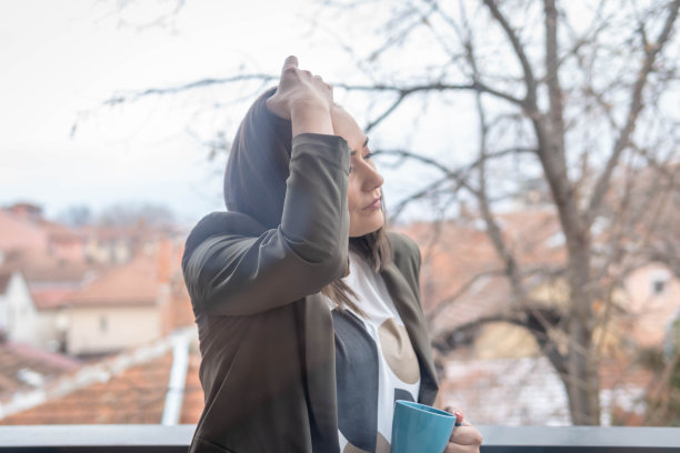 阳台上拿着咖啡放松的女人图片下载