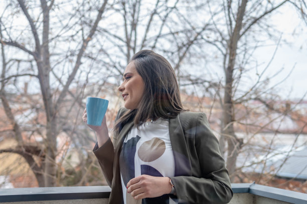 阳台上拿着咖啡放松的女人图片下载