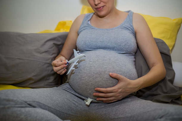 抱着飞机模型的孕妇(孕妇旅游概念)图片下载