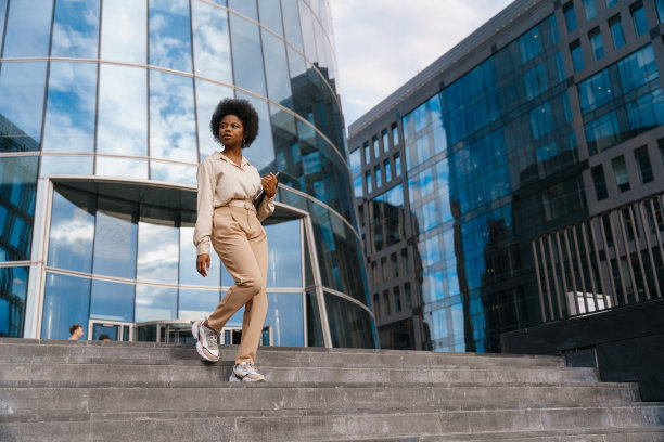 一个深色皮肤的时装模特在日光下走下商业区的楼梯图片下载