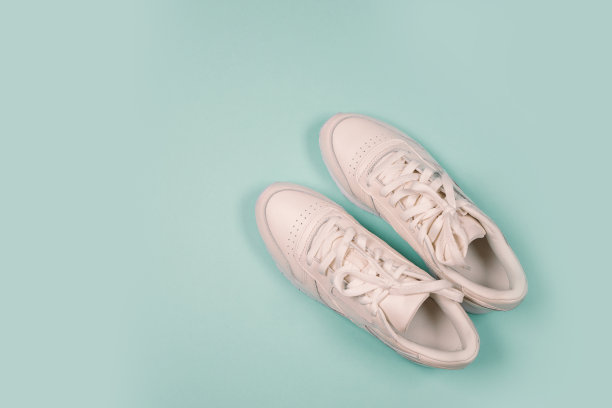 平坦的白色运动运动鞋在蓝色紫色的背景鞋。彩色背景的跑步运动鞋图片下载