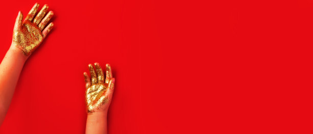 孩子的小手闪着金光。孩子的手闪着金光。节日的旗帜。设计或文本的复制空间。图片下载