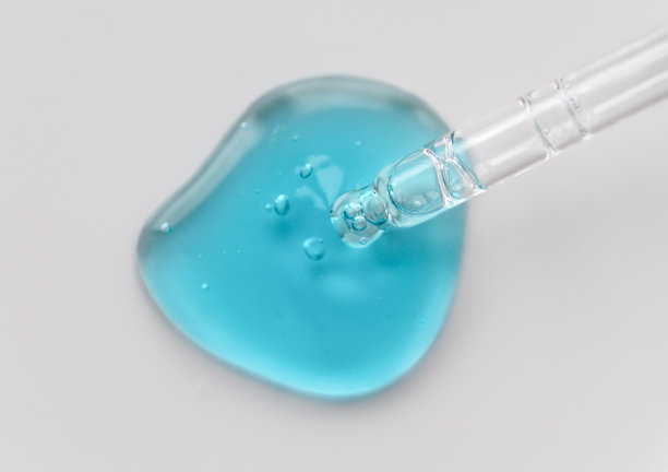 移液管与蓝色液体透明质酸在单色灰色背景。化妆品和保健概念特写图片下载