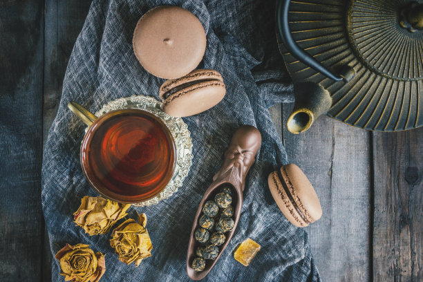 发酵的中国茶在一个陶瓷勺杏仁饼干的背景木桌上一杯茶。有选择性的重点。俯视图图片下载
