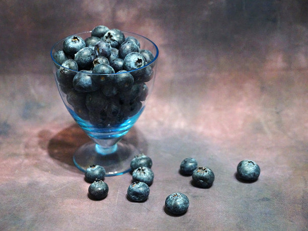 蓝莓装在玻璃杯里，深色的复古背景图片下载
