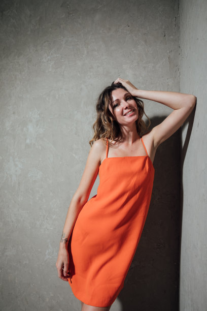 一个美丽时尚的金发女人的肖像在橙色的夏季连衣裙图片下载