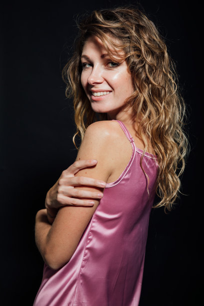 一个美丽的金发女人的肖像在粉红色的丝绸连衣裙图片下载