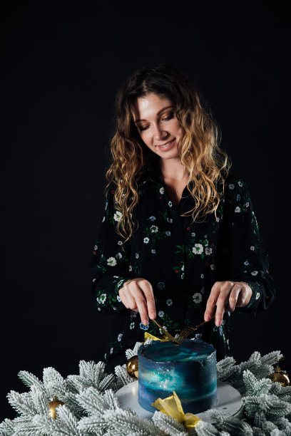 一名妇女切了一个甜的生日蛋糕当食物图片下载