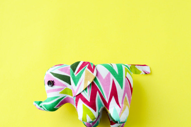 黄色背景上的大象，亮黄色背景上的玩具大象图片下载