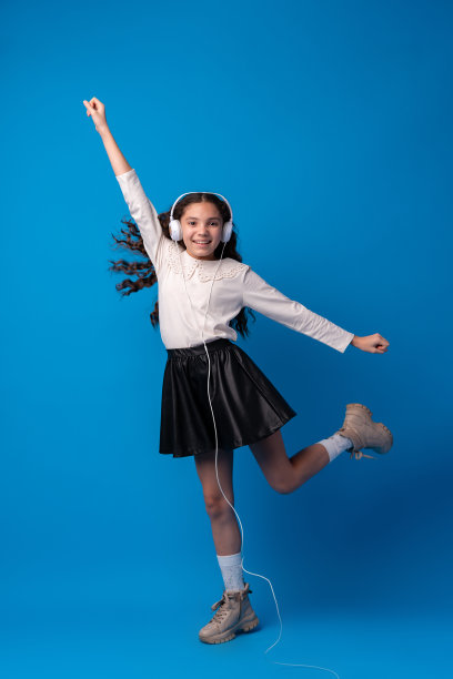 戴着耳机的女生在蓝色背景下听音乐图片下载