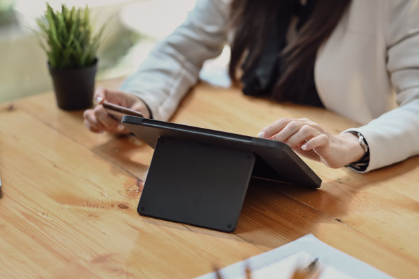 女商人坐在咖啡厅，用平板电脑工作。图片下载