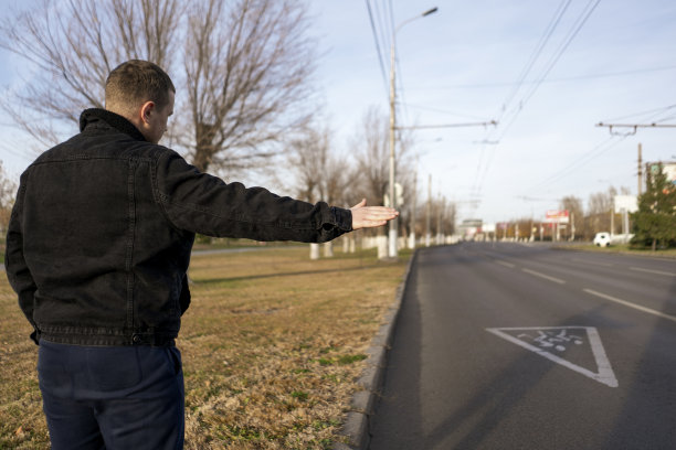 站在高速公路附近的一名男子在城市里搭出租车图片下载