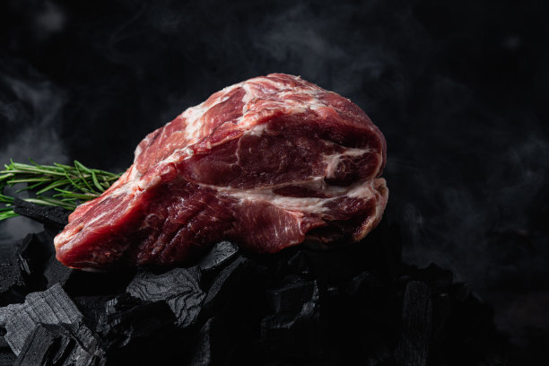 炭火上的一块生猪肉特写图片下载