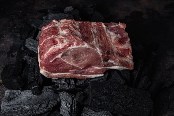 炭火上的一块生猪肉特写图片下载