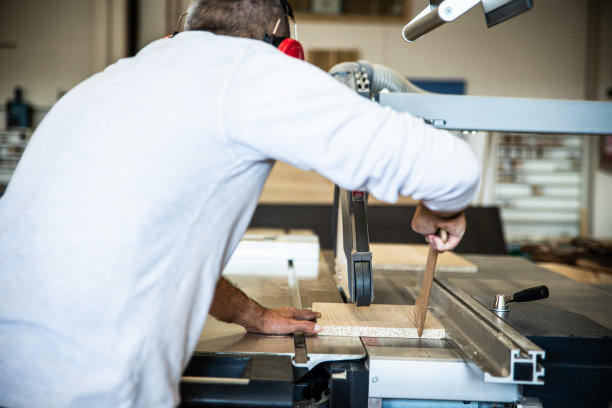 男工匠用圆锯锯木头图片下载