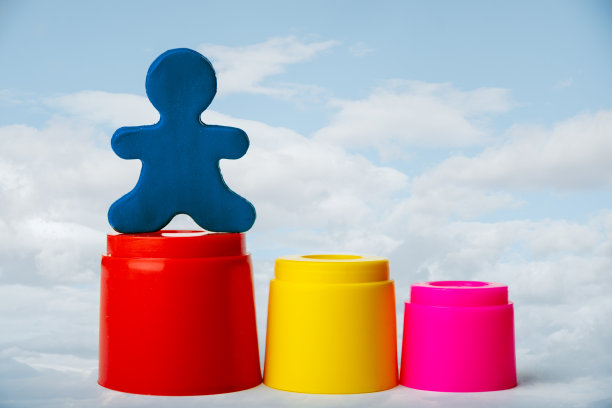 一个橡皮泥人站在最高的讲台上，蓝天白云映衬。领导的概念。图片下载