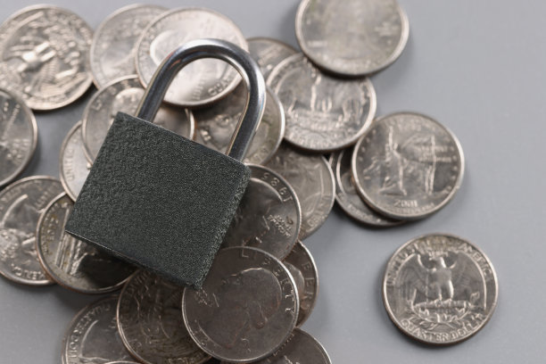 灰色挂锁在银币上，特写镜头，灰色背景图片下载