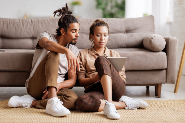 年轻的非裔美国家庭夫妇计划家庭装修，讨论平板电脑设计项目图片下载