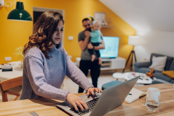 西班牙裔女商人坐在厨房里用她的笔记本电脑工作图片下载