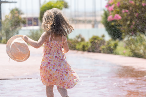 穿着夏装戴着帽子的小女孩跑过水滴图片下载