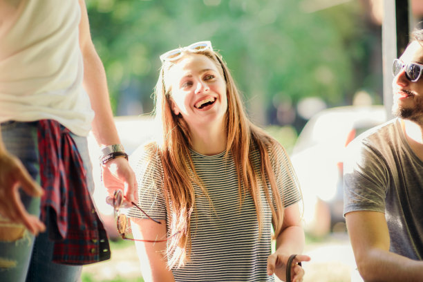 年轻漂亮的女孩我们微笑着坐着图片下载