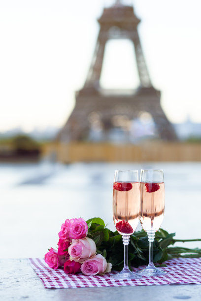 美丽而浪漫的求婚在巴黎-爱情之城。粉红玫瑰花束，两杯红酒，覆盆子。背景是埃菲尔铁塔。关闭复制空间。视图片下载