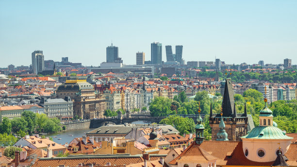 在布拉格，捷克共和国，通过伏尔塔瓦河的查尔斯大桥塔门，可以看到美丽的老城和新的现代商业区的摩天大楼。图片下载