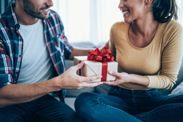 收到男友送的礼物的快乐的年轻女子。图片下载