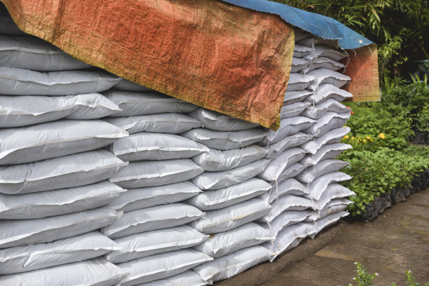 植物商店出售的一袋袋有机肥料，上面盖着厚厚的防水布以防下雨。图片下载