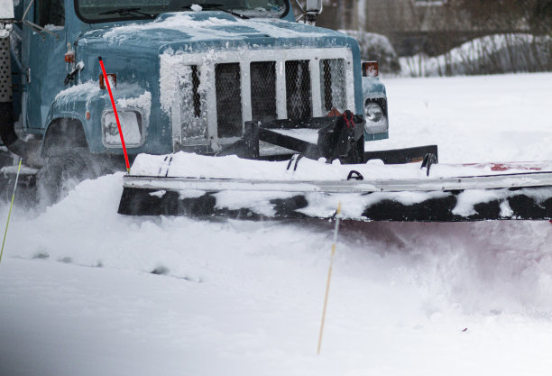 一辆扫雪机推着雪清理住宅区街道的特写镜头图片下载