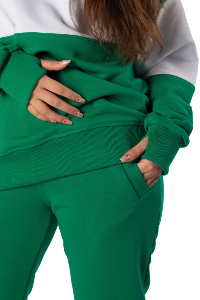 一个女孩的手在运动衫口袋里的特写镜头。一个穿着运动衫的女人的照片碎片。时尚运动装的广告。绿色图片下载