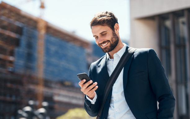 一名年轻商人在城市背景下使用智能手机的照片图片下载