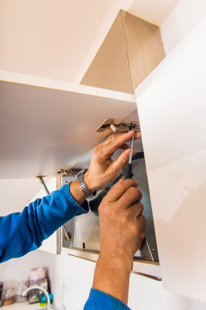 杂工拿着螺丝刀在厨房里图片下载