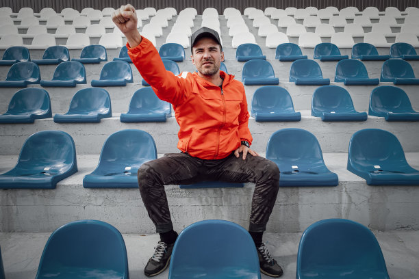 球迷们在体育场的领奖台上鼓掌。在因新冠肺炎疫情被隔离或封锁期间，一名球迷在体育场为他最喜欢的足球队加油图片下载