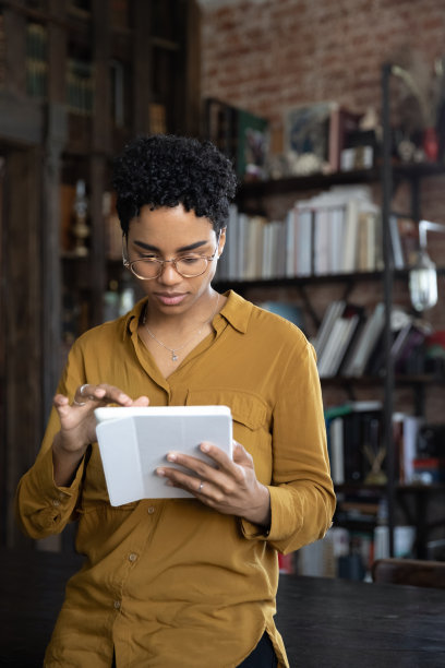 垂直图像集中在年轻的非洲裔美国女性使用平板电脑。图片下载