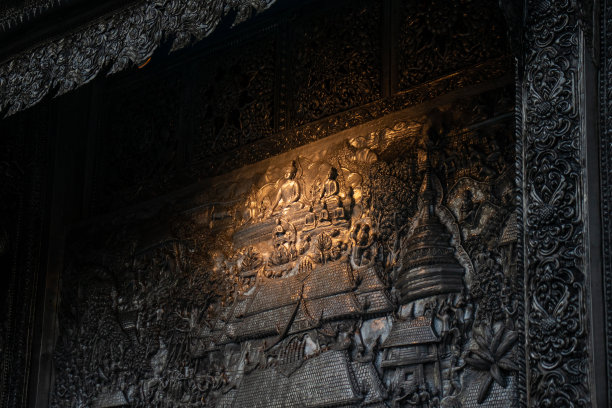 泰国风格的银雕艺术在寺庙的墙壁上，黄色的灯光照耀图片下载