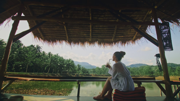 女人喝着鸡尾酒可口的饮料，冰咖啡。旅行者年代图片下载