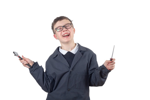 一个十几岁的白人男孩戴着眼镜，穿着黑色的实验服，手里拿着扳手和螺丝刀。一个孤立的男生在一个白色的背景上图片下载