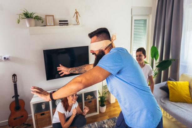 一家人在家里玩捉迷藏，快乐的男孩和爸爸妈妈玩得很开心。图片下载