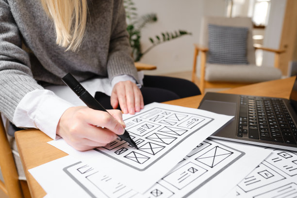 女设计师创建网站设计线框。草图，原型，框架，布局未来设计项目。UI和UX -用户界面，用户体验设计师。网页设计工作室的创意概念图片下载