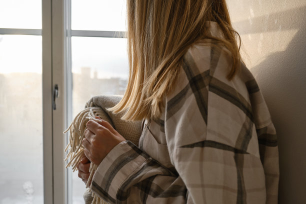 小女孩手里拿着一条舒适柔软的毯子。温暖的毯子在一个女人的手中特写。冬天的心情和家纺图片下载