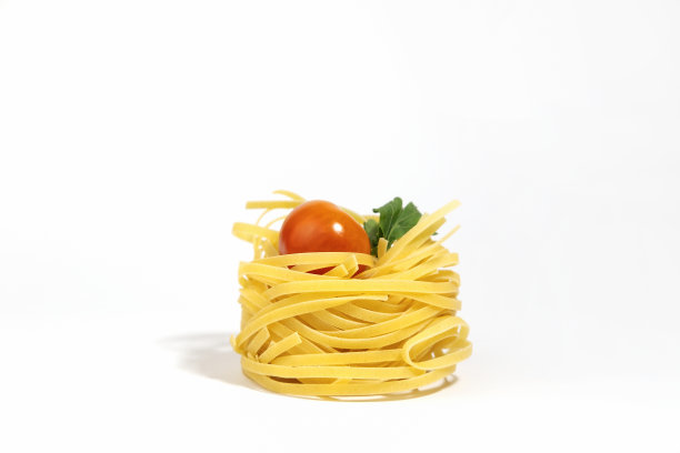 意大利面食。意大利细面条，樱桃番茄和绿色蔬菜，孤立在白色的背景和硬阴影。巢状的意大利面。意面的创意照片。图片下载