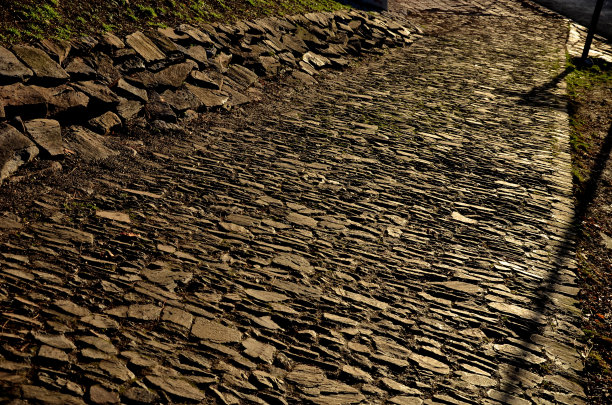 小路上堆着一堆堆的石头，一字排开的红砖。烧过的砖加固了桥下的斜坡。一个清晨。为粗糙的纹理图片下载