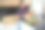 一个快乐的年轻人站在家里的厨房里，从一个环保纸袋里拿出蔬菜和健康食品，手里拿着一根新鲜的番茄，放在厨房的桌子上图片下载