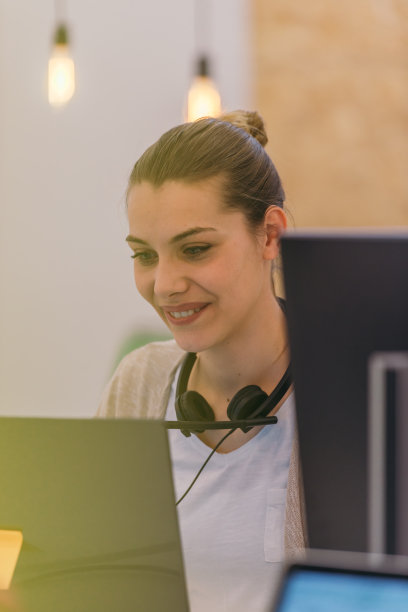 一个年轻的女商人微笑着在工作和她的同事交谈的照片集中图片下载