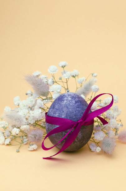 复活节蓝色的彩蛋，奶油色的背景上点缀着满天飞的花朵。图片下载