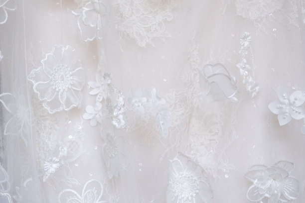 近距离拍摄的白色奢华礼服和闪光图案细节纺织礼服与女性新娘使用。时尚与服装背景概念。图片下载